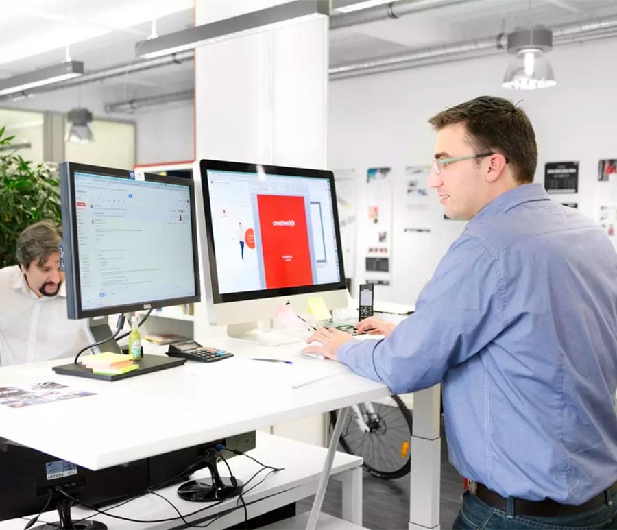 A person sitting in front of two monitors